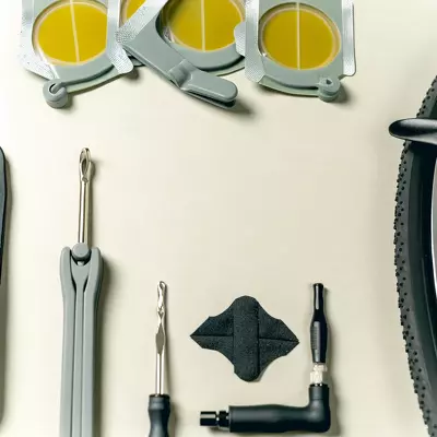 Essential puncture repair kit for road bike enthusiasts, showcasing tire levers, patch kits, a multi-tool, and a mini pump.